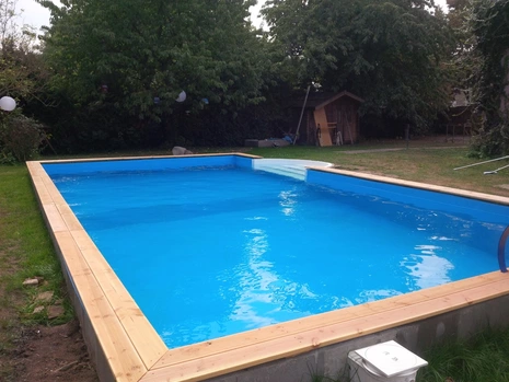 Pool selber bauen mit römischer Badetreppe und Holzumrandung