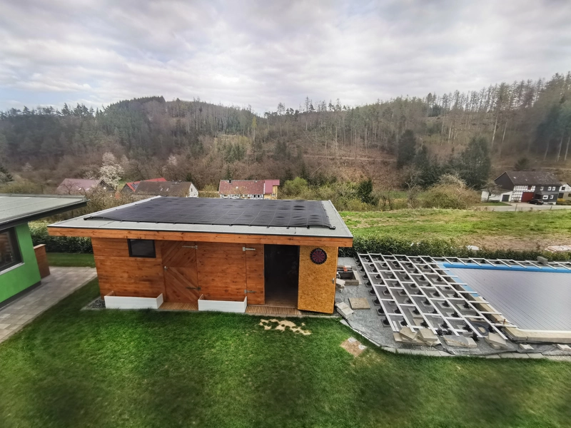 Die solare Poolheizung liegt auf dem Dach der Gartenhütte neben dem Pool
